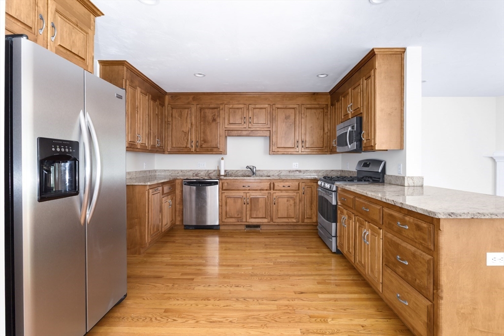 49 Beaver Street, Unit 49 Franklin, MA 02038 - Photo 7 of 46 a kitchen with stainless steel appliances granite countertop a refrigerator sink and cabinets