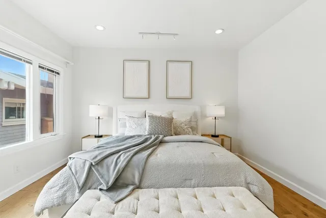 a bedroom with a bed mirror and window