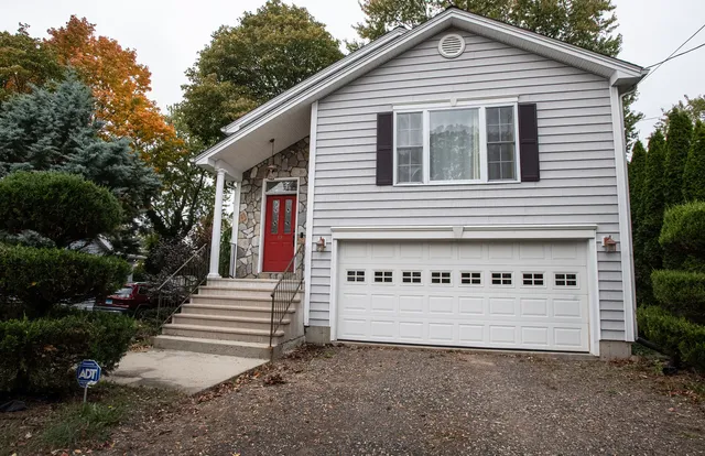 a view of a house with a yard and garage