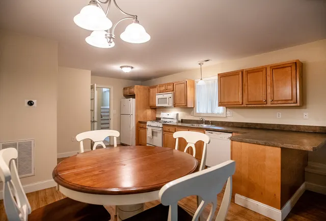 a kitchen with stainless steel appliances granite countertop furniture wooden floor and a refrigerator