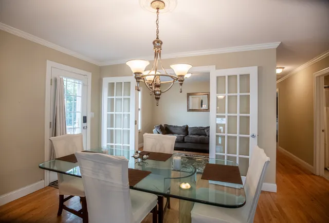 a dining room with furniture a chandelier and wooden floor