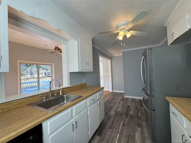 a kitchen with kitchen island white cabinets and stainless steel appliances