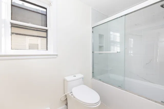 a white toilet sitting next to a bathtub