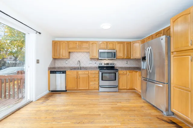 a kitchen with granite countertop a refrigerator stove top oven and sink