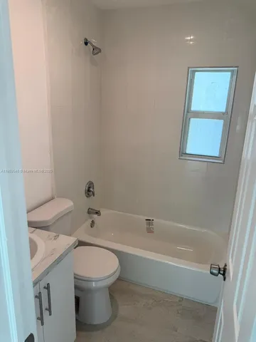 a bathroom with a granite countertop toilet a sink and bathtub