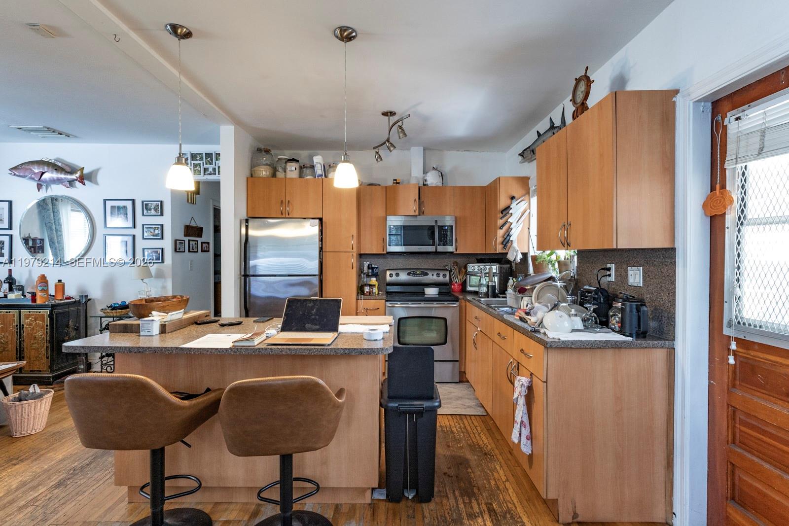2710 Southwest 28th Court Miami, FL 33133 - Photo 9 of 19 a kitchen with granite countertop a sink appliances and cabinets
