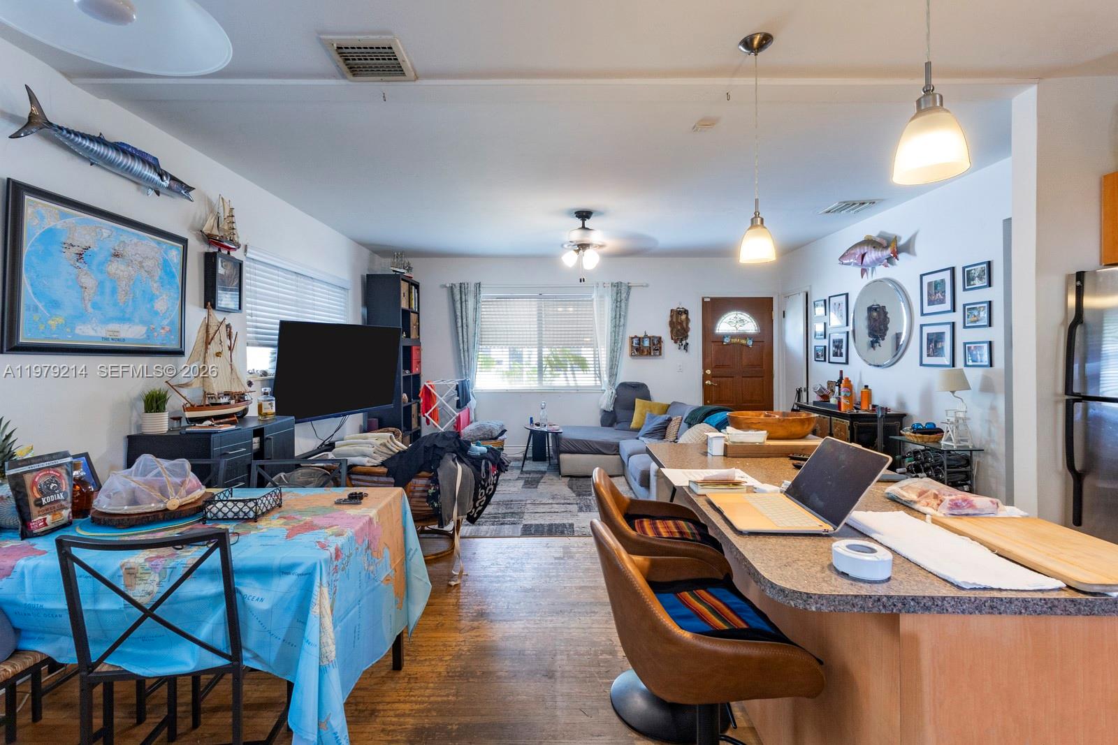 2710 Southwest 28th Court Miami, FL 33133 - Photo 10 of 19 a living room with furniture a flat screen tv and a dining table