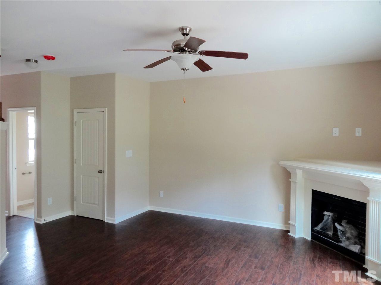 6212 Quitman Trail Raleigh, NC 27610 - Photo 15 of 20 a view of an empty room with wooden floor fireplace and a window