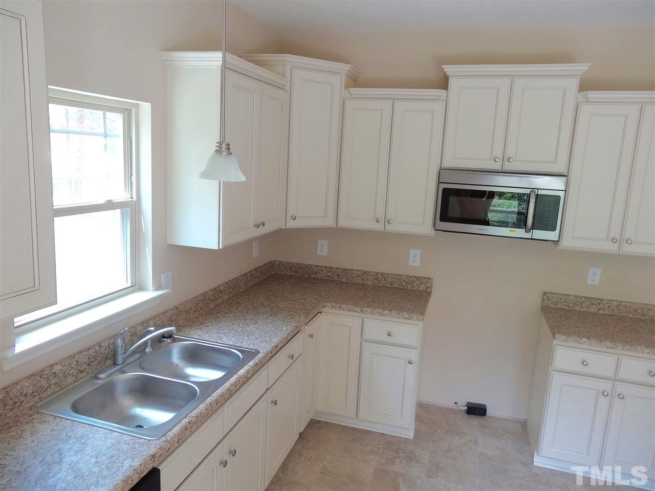 6212 Quitman Trail Raleigh, NC 27610 - Photo 16 of 20 a kitchen with granite countertop white cabinets and a sink