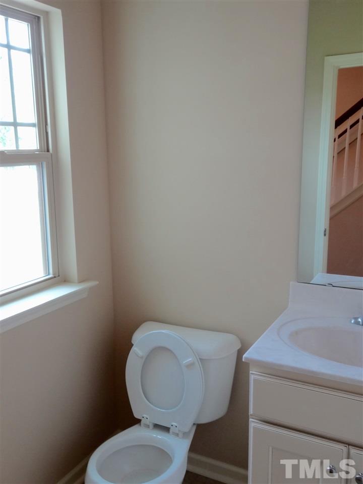 6212 Quitman Trail Raleigh, NC 27610 - Photo 10 of 20 a bathroom with a toilet a sink and a window