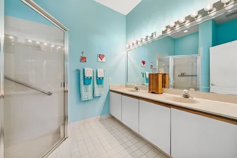 a large white kitchen with a sink and a large mirror