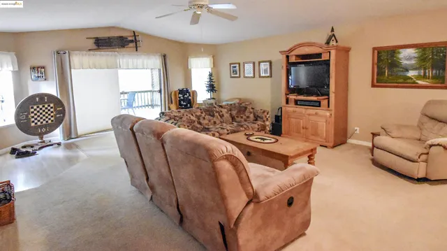a living room with furniture a flat screen tv and outdoor view