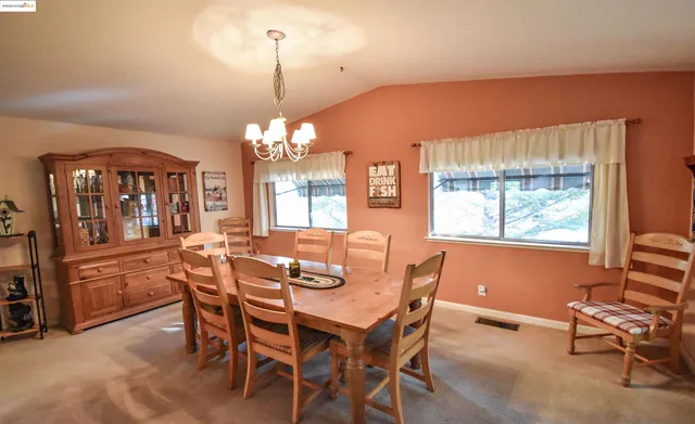 a dining room with furniture a chandelier and window