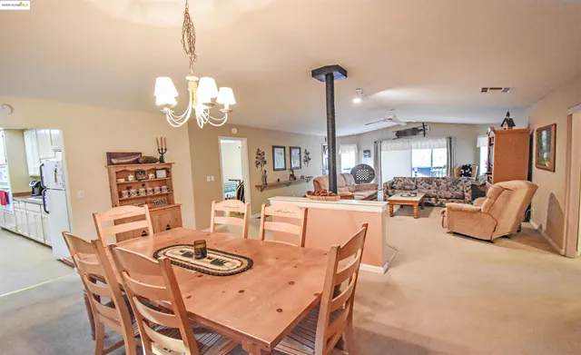 a view of a dining room and livingroom with furniture wooden floor a chandelier