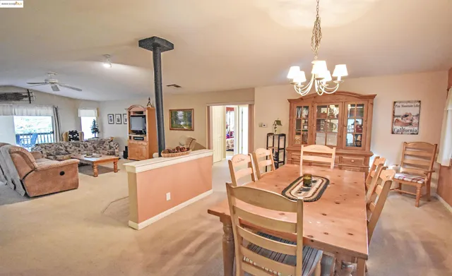a view of a dining room and livingroom with furniture wooden floor a chandelier