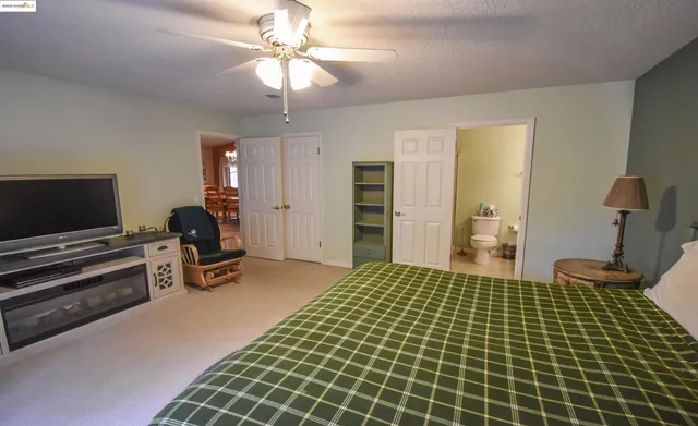 a bedroom with furniture and a flat screen tv