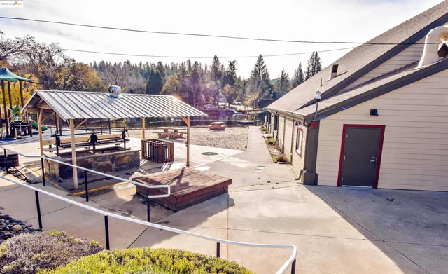 a view of a patio with a table and chairs under an umbrella