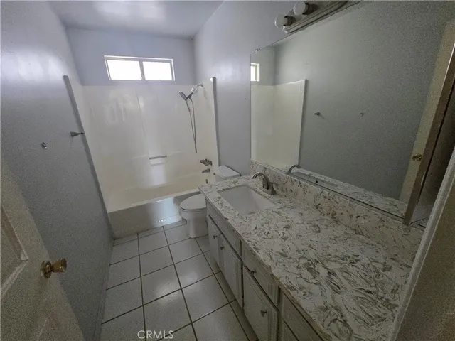 a bathroom with a granite countertop sink a toilet and a mirror