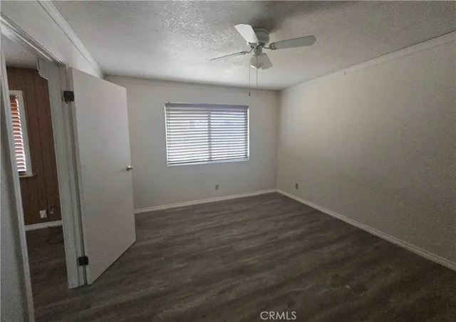 an empty room with wooden floor and window