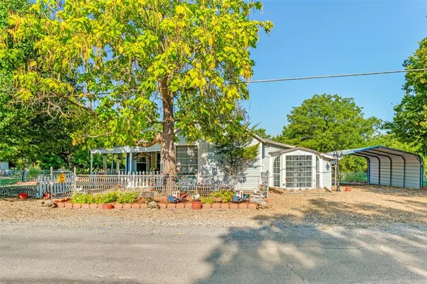 a backyard of a house with table and chairs and potted plants