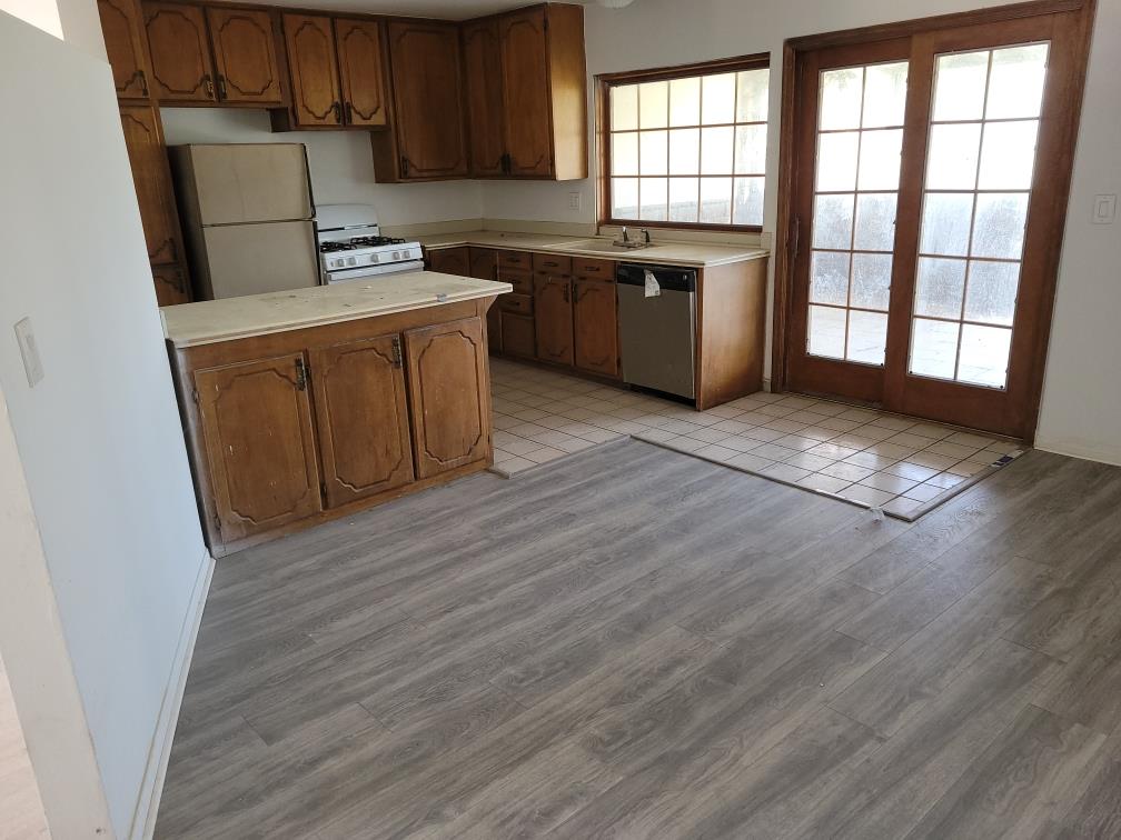 a kitchen with a wooden floor and a refrigerator