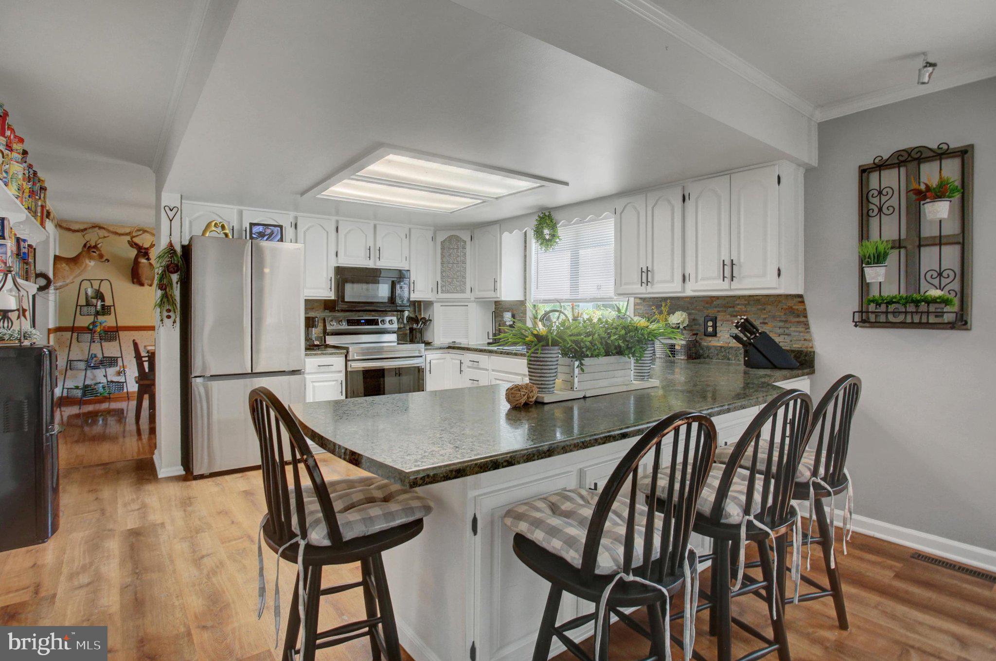 11086 Welsh Run Road Greencastle, PA 17225 - Photo 17 of 63 a kitchen with stainless steel appliances granite countertop a table chairs and a refrigerator