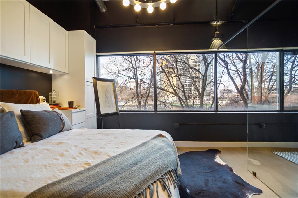 120 Ralph McGill Boulevard Northeast, Unit 405 Atlanta, GA 30308 - Photo 14 of 32 a bedroom with a bed and wooden floor