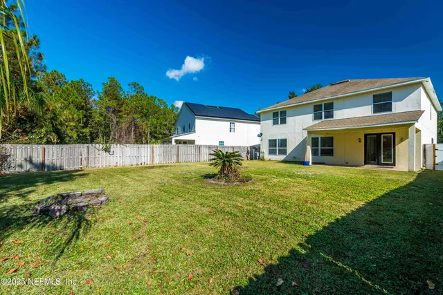 a view of a house with backyard and a garden