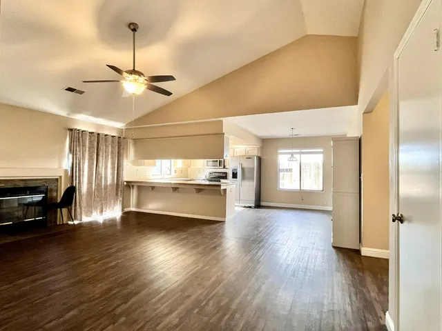 a view of a kitchen with a stove wooden cabinet a refrigerator and wooden floor