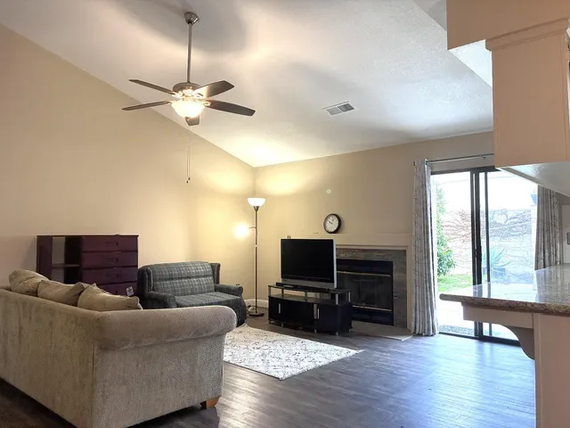 a living room with furniture a flat screen tv and a fireplace