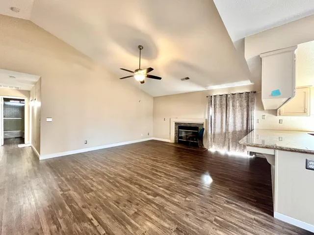 a view of a livingroom with wooden floor and a fireplace