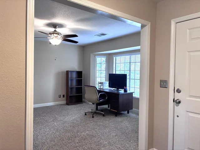 a view of a livingroom with workspace and a window