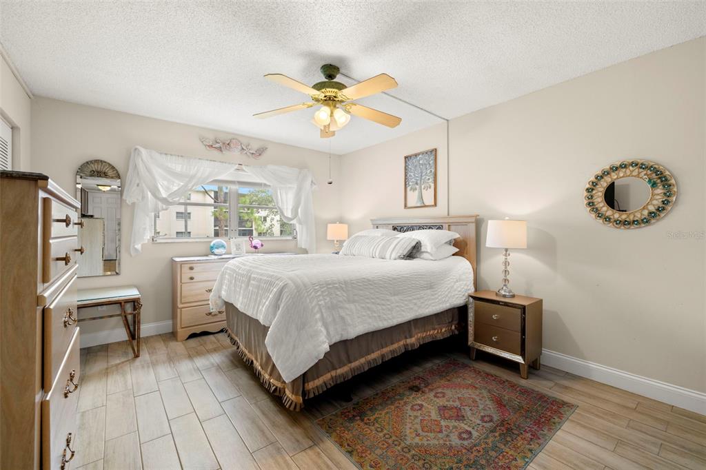 1370 Heather Ridge Boulevard, Unit 105 Dunedin, FL 34698 - Photo 14 of 56 a bedroom with a bed and a chandelier