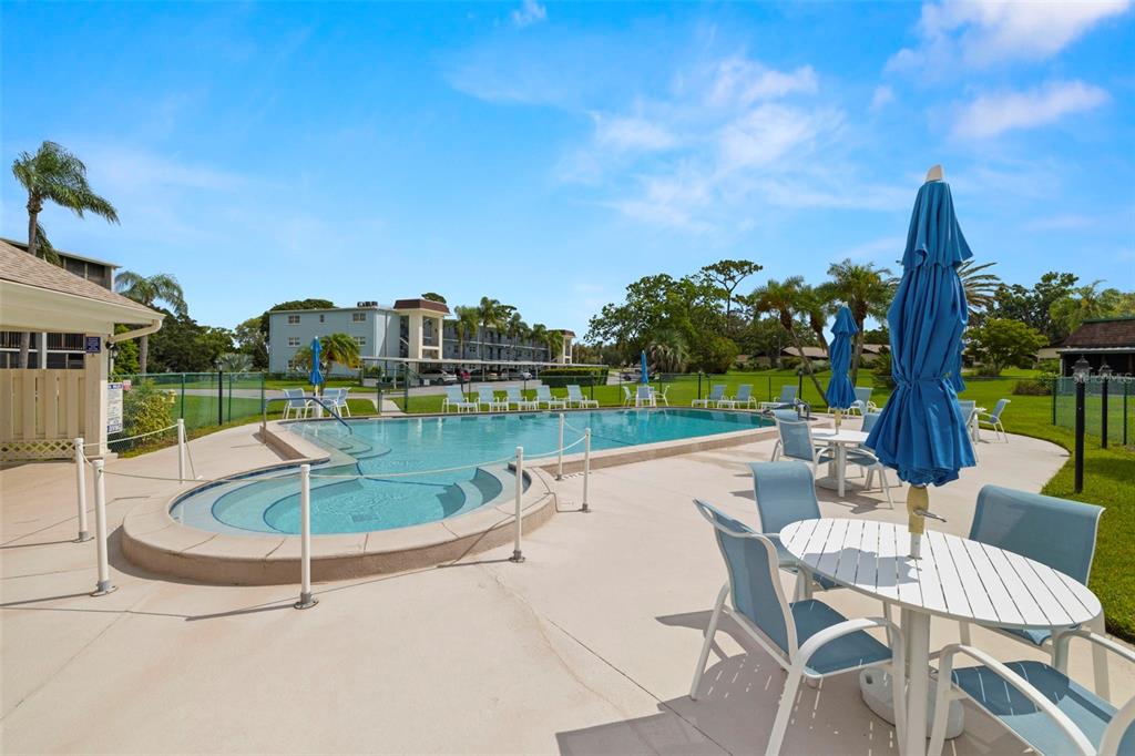 1370 Heather Ridge Boulevard, Unit 105 Dunedin, FL 34698 - Photo 26 of 56 a swimming pool with outdoor seating and yard
