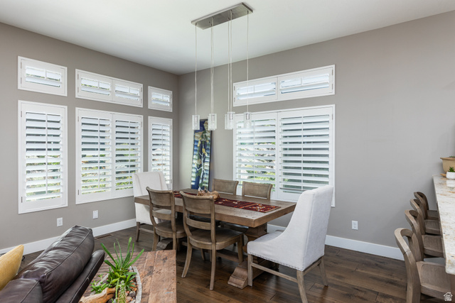 1132 Sunset Dunes Way Draper, UT 84020 - Photo 9 of 35 Dining area featuring rich wood-finish flooring, multiple windows with white plantation shutters, and a modern linear pendant light fixture