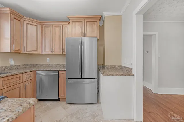 a kitchen with stainless steel appliances granite countertop a refrigerator and a stove