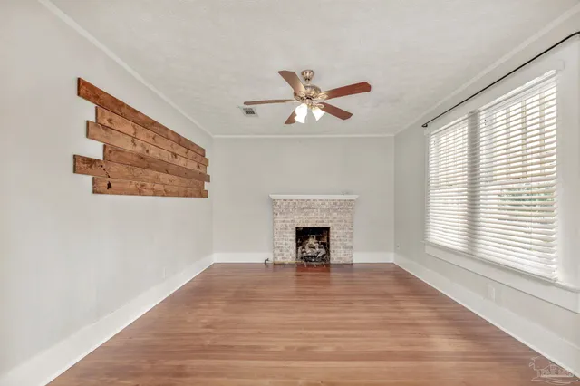 a view of an empty room with a window and a fireplace