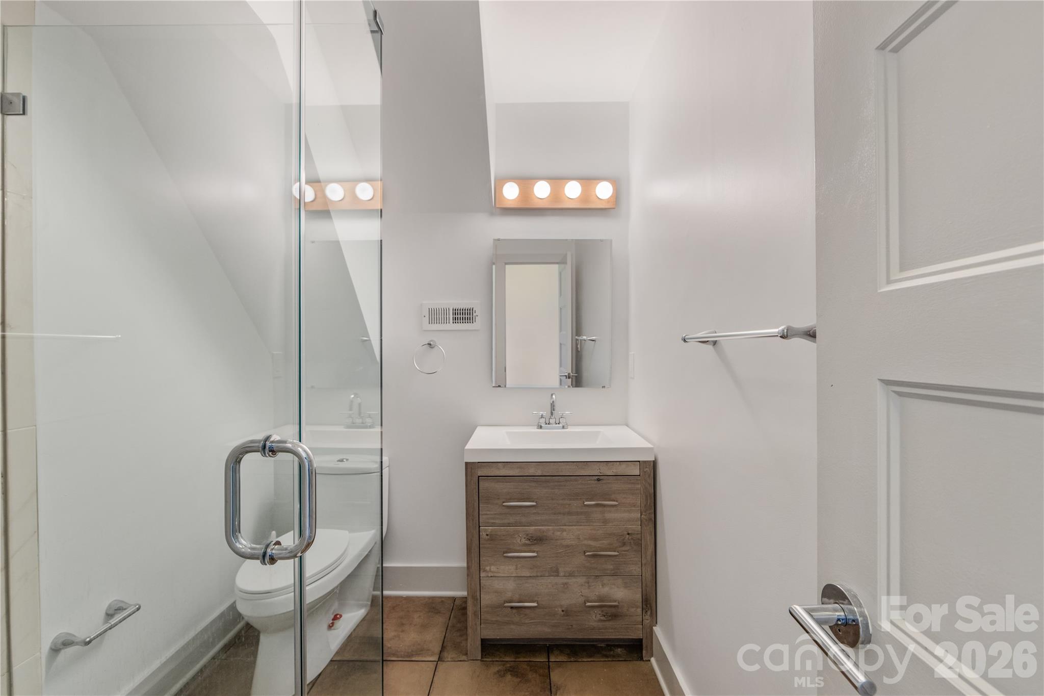 6229 Springfield Drive Charlotte, NC 28212 - Photo 32 of 44 a bathroom with a mirror a sink and shower