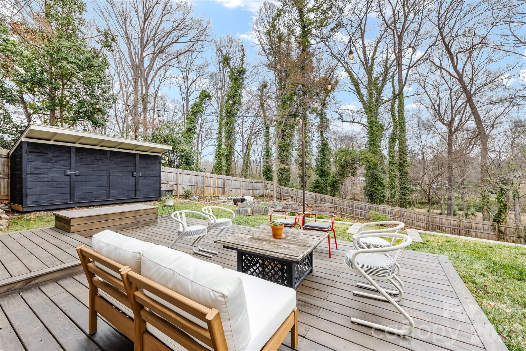 6229 Springfield Drive Charlotte, NC 28212 - Photo 36 of 44 a view of a patio with couches table and chairs and potted plants with wooden floor and fence