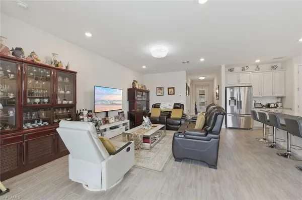 a living room with lots of furniture wooden floor and a large window