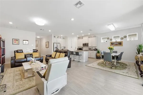 a living room with lots of furniture and kitchen view