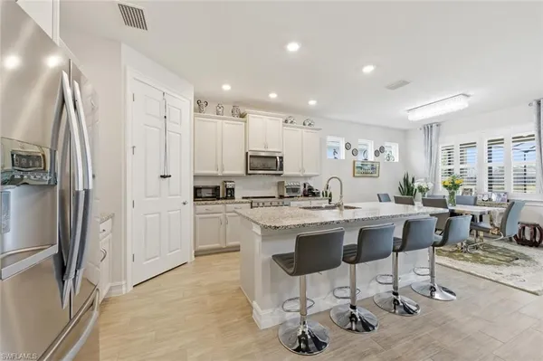 a kitchen with stainless steel appliances granite countertop a refrigerator and a stove top oven