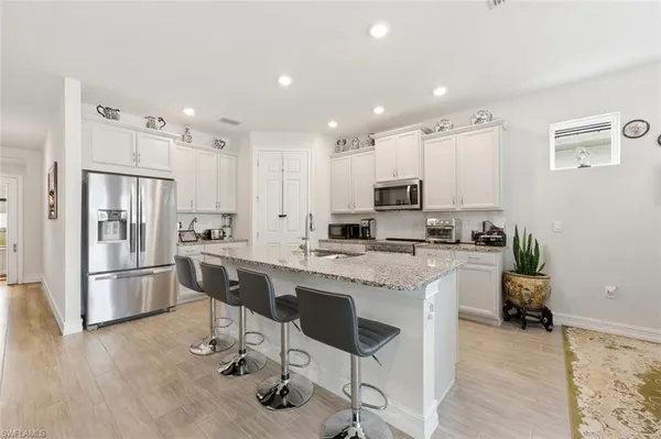 a kitchen with stainless steel appliances granite countertop a refrigerator and a stove top oven