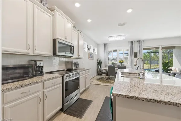 a kitchen with stainless steel appliances granite countertop a stove a sink and a microwave