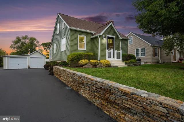 a front view of a house with a yard and trees