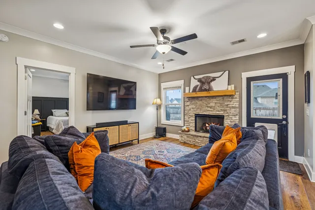 a living room with furniture a flat screen tv and a fireplace