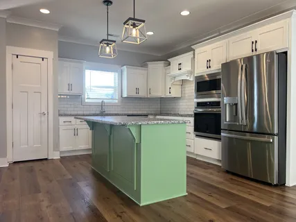 a kitchen with kitchen island granite countertop a sink cabinets and stainless steel appliances