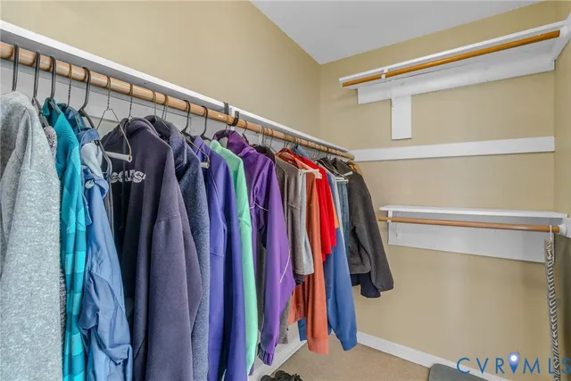 a view of walk in closet with clothes