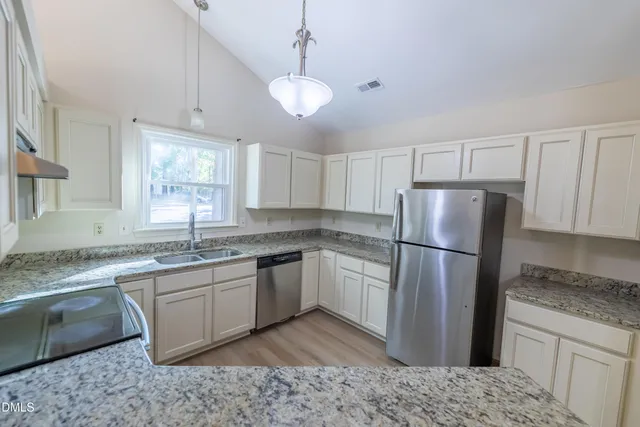 a kitchen with a refrigerator sink and cabinets