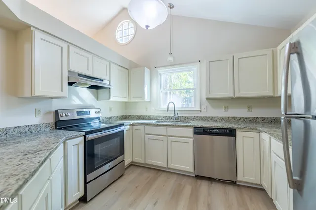 a kitchen with stainless steel appliances granite countertop a sink stove and refrigerator